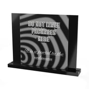 The "Do Not Leave Packages Here, It is a Portal to the Unknown" acrylic sign by Printify features a black and white swirling design, bold warning text, script quote, and sits on a sleek black rectangular base.