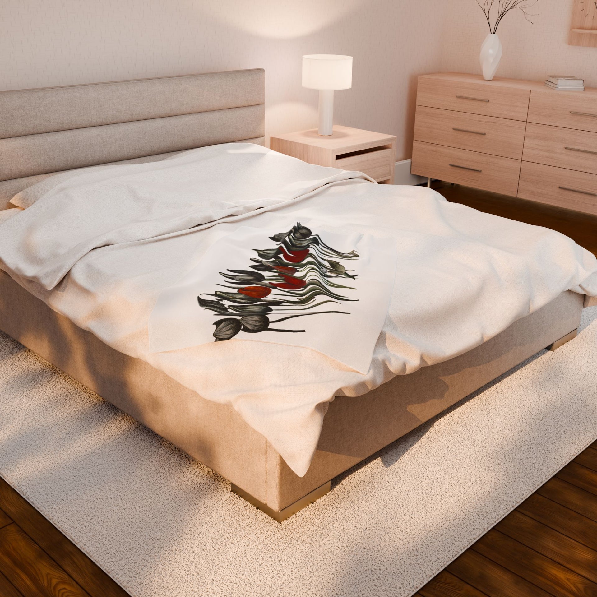 A neatly made bed features a beige headboard and white bedding, adorned with the Gothic Floral Velveteen Plush Blanket–White by Printify. To the left is a wooden nightstand with a lit lamp, while on the right, a matching dresser holds a vase. A plush rug enhances the wooden floors understated gothic elegance.
