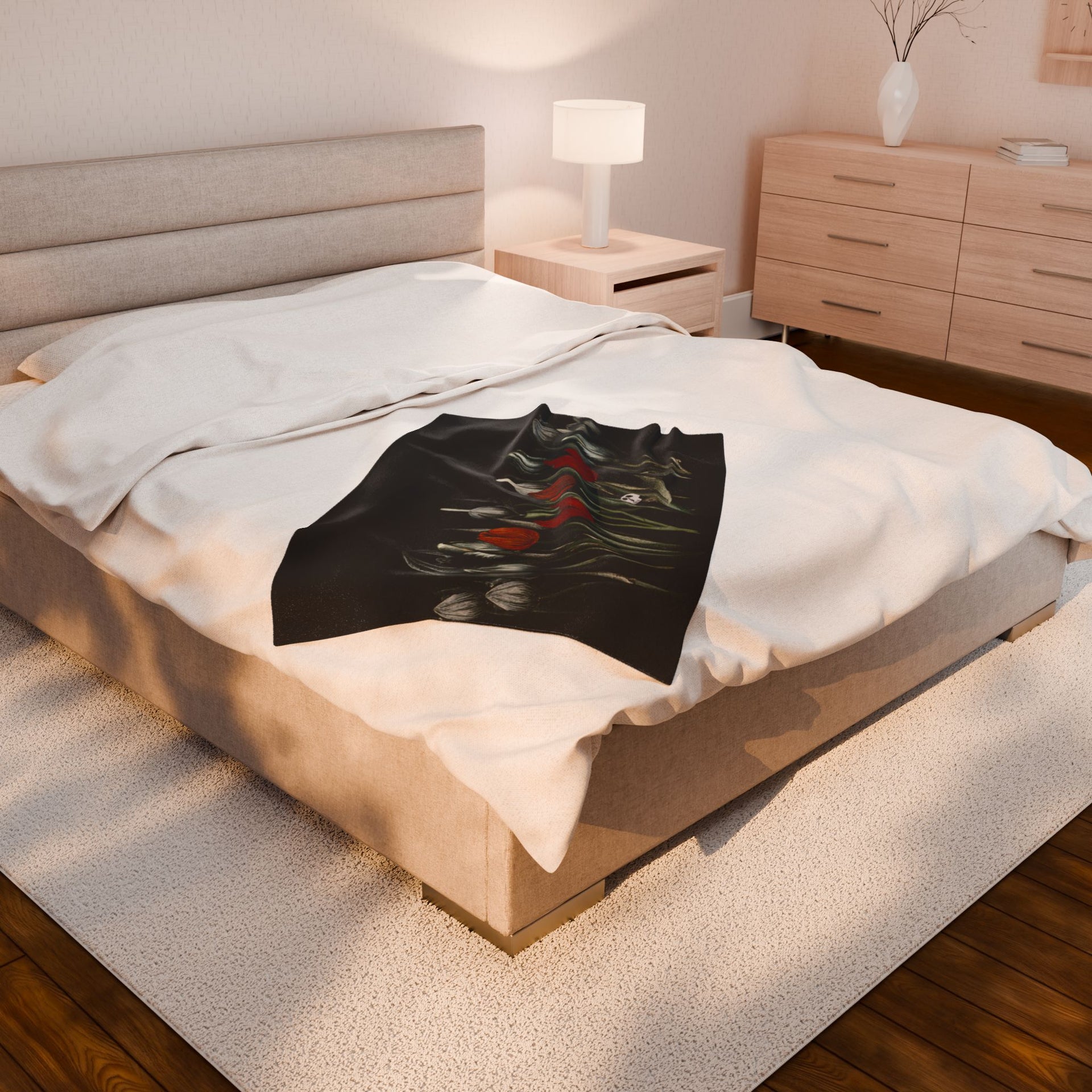 A cozy bedroom with gothic elegance features a large bed adorned with Printifys Gothic Floral Velveteen Plush Blanket in black, complemented by a beige headboard, wooden nightstand, lamp, dresser, and a plush beige rug warming the wooden floor.