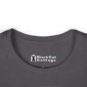 Close-up of a dark gray FAFO Gritty IYKYK Women's T shirt collar by Printify, featuring a printed Black Cat Cottage label and black cat icon with an "L" for size—ideal for anyone seeking a comfy, casual tee.